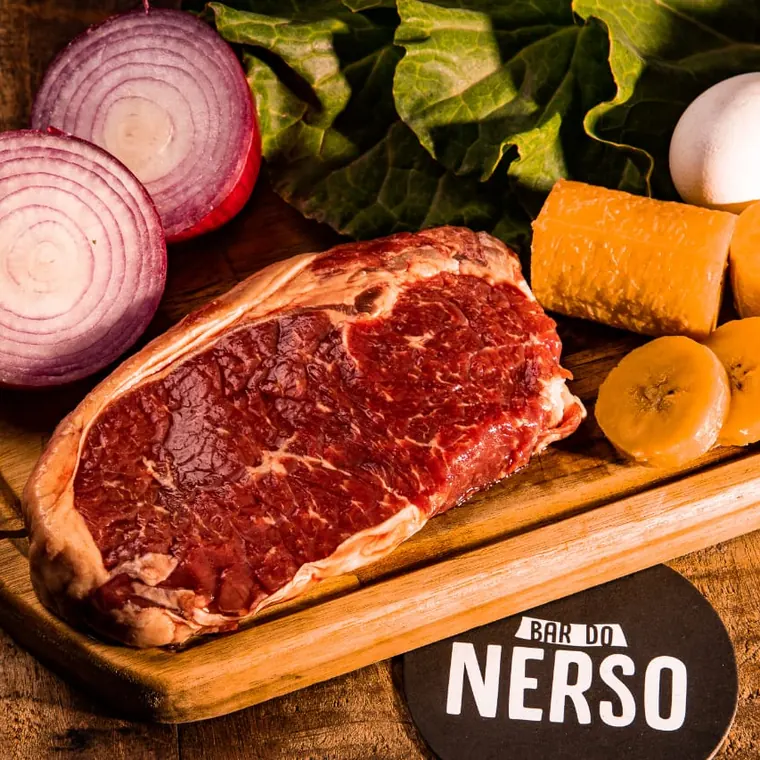 Corte bovino 100% Angus cru na tábua, com o marmoreio à vista e o porta-copos da casa