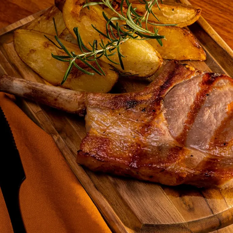Corte na brasa servido com batatas rústicas e alecrim