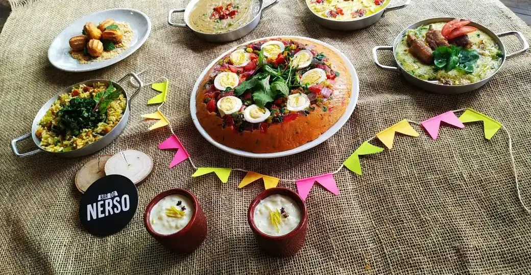 Mesa de festa montada com bandeirolas, docinhos e petiscos