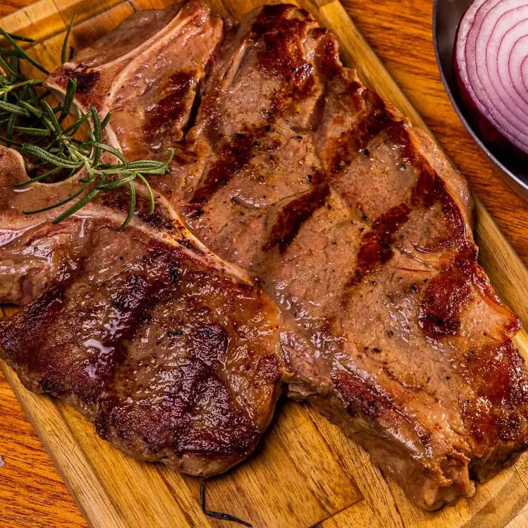 T-bone servido na tábua com alecrim, sal grosso e cebola roxa